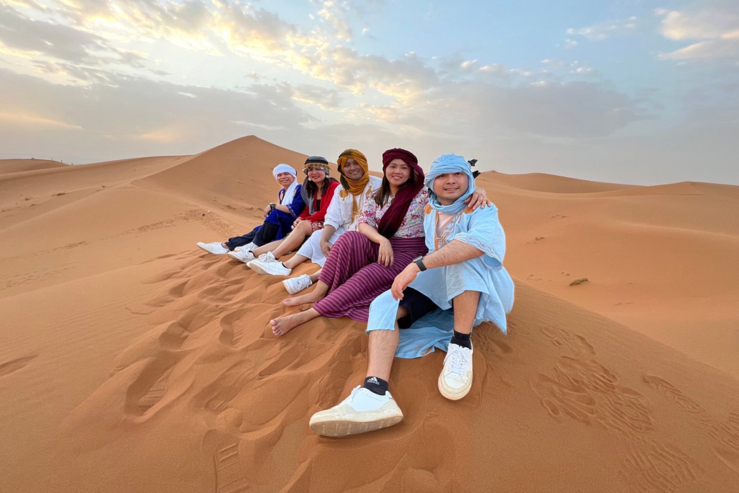 Group of guests sitting together on a Merzouga dune